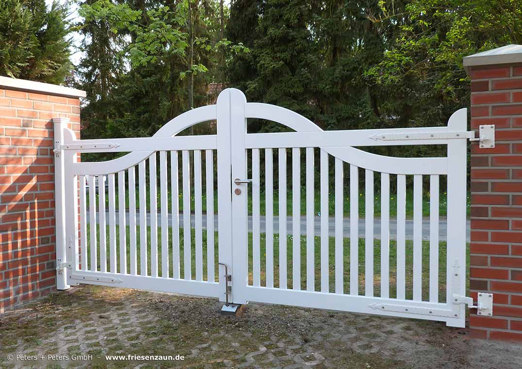 Orignal Sylter Friesentor als weißes Hoftor zwischen gemauerten Torpfosten.