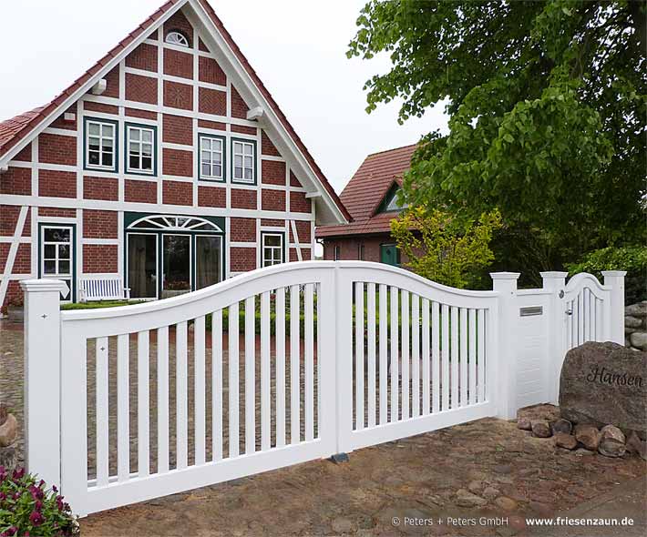 Die weißen Gartentore von Peters + Peters passen zu vielen Haustypen - hiert ein Gartentor Schleswig vor einem klassischem Fachwerkhaus.